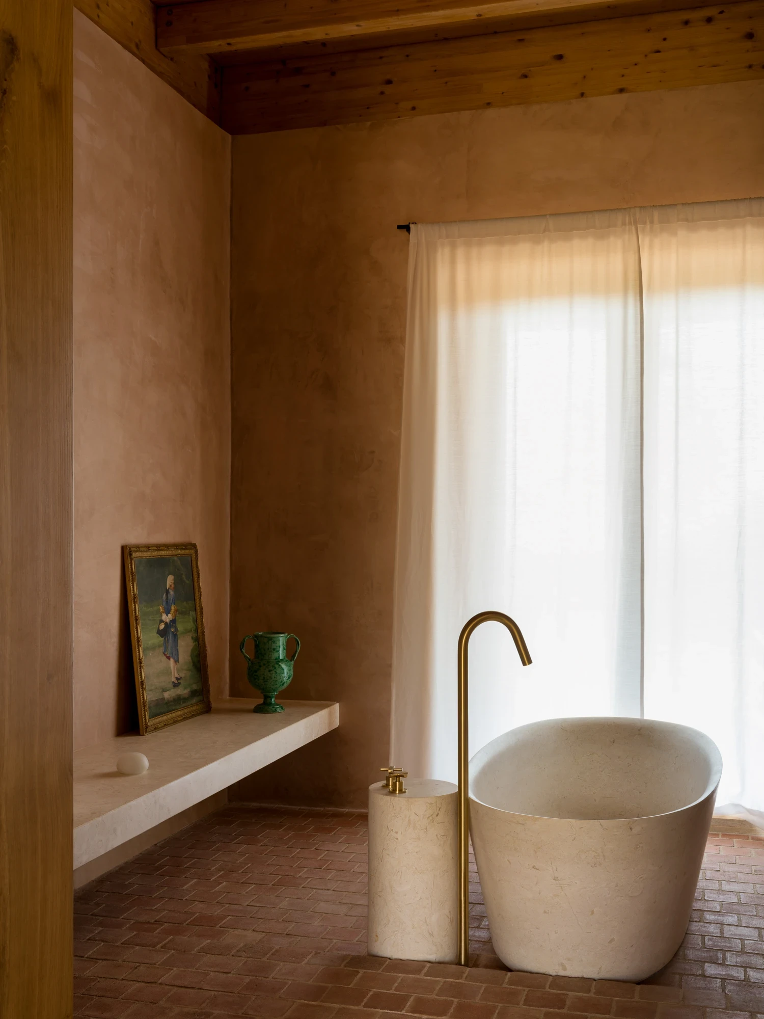 Stone bathtub beside a curtained window