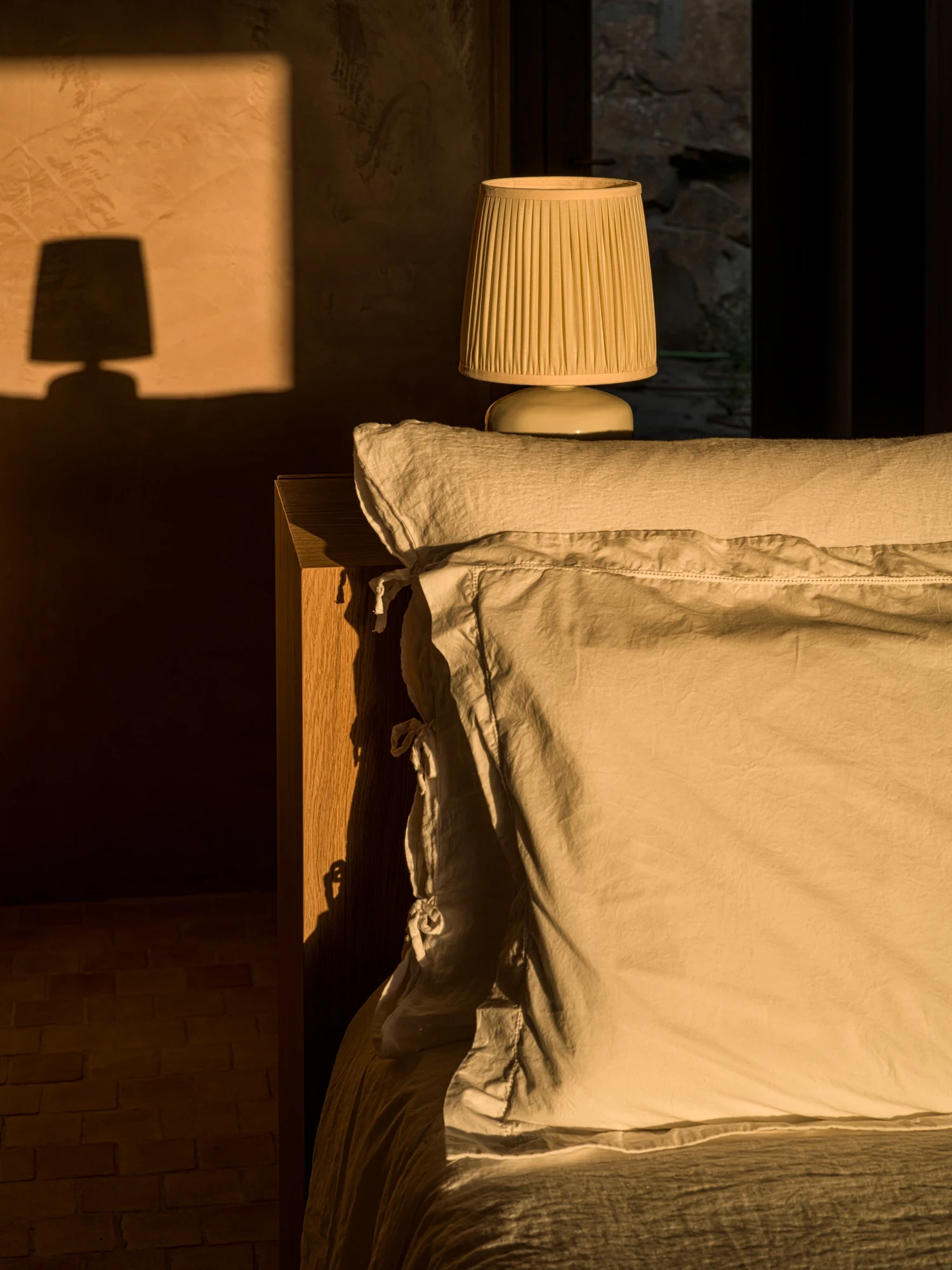 Linen pillow and lamp in the warm shadow