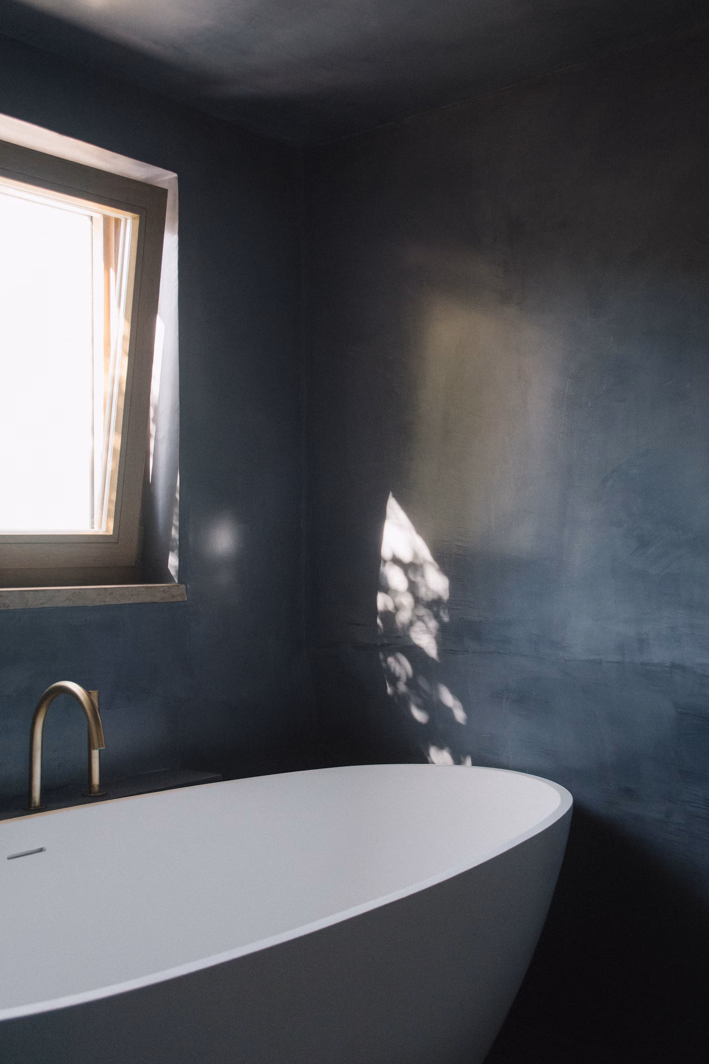 Dark plaster bathroom with freestanding tub